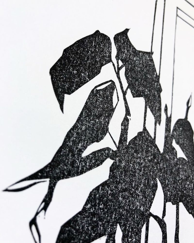 Black linocut of a houseplant silhouette beside a window frame